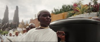 Movie still from “Black Panther: Wakanda Forever” (2022), directed by Ryan Coogler – A woman in a white dress is standing outside; Close Up shot, Low angle