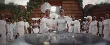 Movie still from “Black Panther: Wakanda Forever” (2022), directed by Ryan Coogler – A couple of people that are standing in front of a table; Wide shot, Low angle