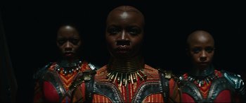 Movie still from “Black Panther: Wakanda Forever” (2022), directed by Ryan Coogler – A woman in a red and black outfit and a man in a red and black outfit; Close Up shot, Low angle