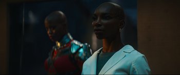Movie still from “Black Panther: Wakanda Forever” (2022), directed by Ryan Coogler – A woman in a white jacket and a man in a black suit; Close Up shot, Over the shoulder angle