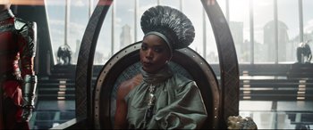 Movie still from “Black Panther: Wakanda Forever” (2022), directed by Ryan Coogler – A black woman with a headdress sitting in a chair; Medium shot, Over the shoulder angle