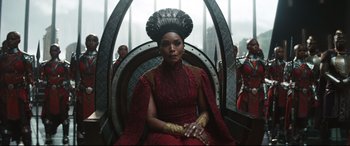 Movie still from “Black Panther: Wakanda Forever” (2022), directed by Ryan Coogler – A woman sitting on top of a chair wearing a crown; Medium shot, Over the shoulder angle