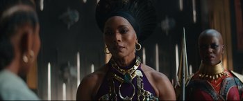 Movie still from “Black Panther: Wakanda Forever” (2022), directed by Ryan Coogler – A woman in a purple dress and a black headdress; Close Up shot, Low angle