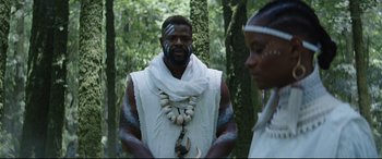 Movie still from “Black Panther: Wakanda Forever” (2022), directed by Ryan Coogler – A man and a woman dressed in white standing in the woods; Medium shot, Over the shoulder angle