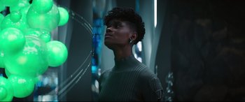 Movie still from “Black Panther: Wakanda Forever” (2022), directed by Ryan Coogler – A woman in a green sweater looking up at the sky; Close Up shot, Low angle