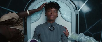 Movie still from “Black Panther: Wakanda Forever” (2022), directed by Ryan Coogler – A woman sitting in a chair with her eyes closed; Close Up shot, Over the shoulder angle