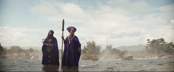 Movie still from “Black Panther: Wakanda Forever” (2022), directed by Ryan Coogler – Two men in purple robes standing in the water; Extreme Wide shot, Low angle