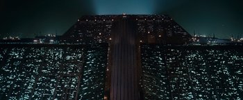 Movie still from “Blade Runner” (1982), directed by Ridley Scott – A view of a skyscraper at night from the ground level; Extreme Wide shot, Low angle