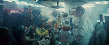 Movie still from “Blade Runner” (1982), directed by Ridley Scott – A group of people sitting at a table with drinks; Medium shot, High angle