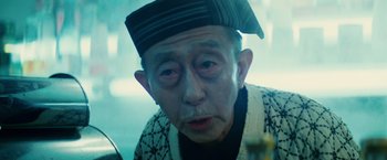 Movie still from “Blade Runner” (1982), directed by Ridley Scott – An older man wearing a hat and looking at the camera; Close Up shot, Low angle