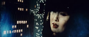 Movie still from “Blade Runner” (1982), directed by Ridley Scott – A woman's face in front of a city skyline at night; Extreme Close Up shot, Over the shoulder angle