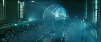 Movie still from “Blade Runner” (1982), directed by Ridley Scott – People are standing in a train station at night; Extreme Wide shot, Low angle