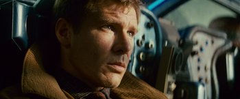 Movie still from “Blade Runner” (1982), directed by Ridley Scott – A person wearing a suit and tie; Close Up shot, Low angle