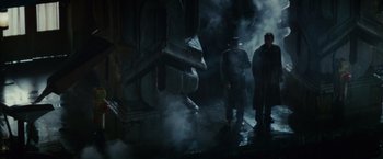 Movie still from “Blade Runner” (1982), directed by Ridley Scott – Two men standing in the middle of a foggy room; Wide shot, Low angle