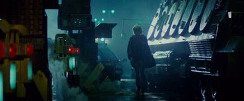 Movie still from “Blade Runner” (1982), directed by Ridley Scott – A person walking down a street at night; Wide shot, Low angle