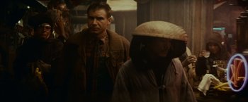 Movie still from “Blade Runner” (1982), directed by Ridley Scott – A man and a woman standing next to each other; Medium shot, Over the shoulder angle