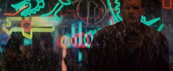 Movie still from “Blade Runner” (1982), directed by Ridley Scott – A person standing in front of a neon light sign; Close Up shot, Over the shoulder angle