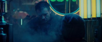 Movie still from “Blade Runner” (1982), directed by Ridley Scott – A man sitting in front of a neon sign; Close Up shot, Over the shoulder angle