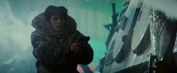 Movie still from “Blade Runner” (1982), directed by Ridley Scott – A woman holding a gun while standing in the rain; Medium shot, Low angle