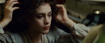 Movie still from “Blade Runner” (1982), directed by Ridley Scott – A young woman sitting on the floor with her hand in her hair; Close Up shot, High angle