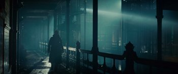 Movie still from “Blade Runner” (1982), directed by Ridley Scott – A person standing on a balcony in the dark; Wide shot, Low angle