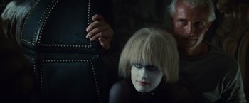 Movie still from “Blade Runner” (1982), directed by Ridley Scott – A woman with white makeup sitting next to a man; Close Up shot, Over the shoulder angle