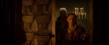 Movie still from “Blade Runner” (1982), directed by Ridley Scott – A man and a woman standing in front of a wooden door; Medium shot, Over the shoulder angle