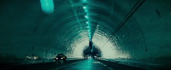 Movie still from “Blade Runner” (1982), directed by Ridley Scott – Cars driving down a road through a tunnel; Extreme Wide shot, High angle