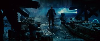 Movie still from “Blade Runner” (1982), directed by Ridley Scott – A man standing in the middle of an alley; Wide shot, High angle