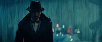 Movie still from “Blade Runner” (1982), directed by Ridley Scott – A man wearing a hat and a coat standing in the rain; Close Up shot, Low angle