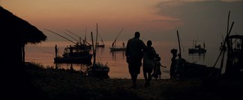 Movie still from “Blood Diamond” (2006), directed by Edward Zwick – A man and a child walking on the beach at sunset; Extreme Wide shot, Low angle