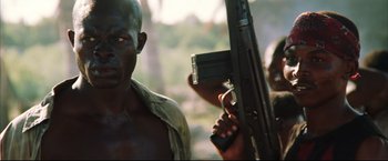 Movie still from “Blood Diamond” (2006), directed by Edward Zwick – A man holding a gun while standing next to another man; Close Up shot, Low angle