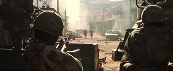 Movie still from “Blood Diamond” (2006), directed by Edward Zwick – A soldier in camouflage is looking out over a street; Wide shot, High angle