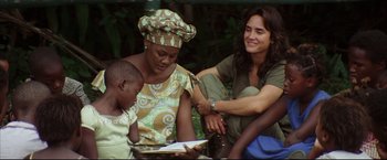 Movie still from “Blood Diamond” (2006), directed by Edward Zwick – Two women and a child sitting on the ground; Medium shot, High angle