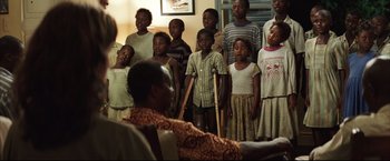 Movie still from “Blood Diamond” (2006), directed by Edward Zwick – A group of children singing in a living room; Wide shot, Low angle