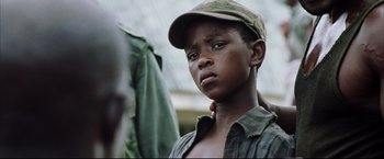 Movie still from “Blood Diamond” (2006), directed by Edward Zwick – A young boy wearing a hat and a plaid shirt; Close Up shot, Low angle