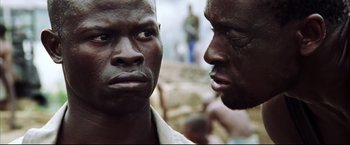 Movie still from “Blood Diamond” (2006), directed by Edward Zwick – Two black men standing next to each other; Close Up shot, Over the shoulder angle