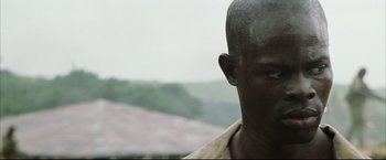 Movie still from “Blood Diamond” (2006), directed by Edward Zwick – A man's face in front of mountains; Close Up shot, Low angle