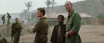 Movie still from “Blood Diamond” (2006), directed by Edward Zwick – A group of men standing next to each other in the dirt; Medium shot, Over the shoulder angle