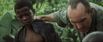 Movie still from “Blood Diamond” (2006), directed by Edward Zwick – A man with his arm around another man's shoulder; Close Up shot, Over the shoulder angle