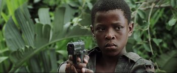 Movie still from “Blood Diamond” (2006), directed by Edward Zwick – A young man holding a gun in his hand; Close Up shot, Low angle