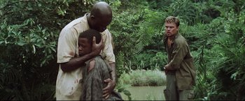 Movie still from “Blood Diamond” (2006), directed by Edward Zwick – A man is hugging a young boy in the woods; Medium shot, Over the shoulder angle