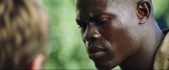Movie still from “Blood Diamond” (2006), directed by Edward Zwick – A man's face in a forest; Extreme Close Up shot, Low angle