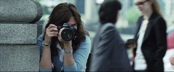 Movie still from “Blood Diamond” (2006), directed by Edward Zwick – A woman taking a picture of a man in a business suit; Close Up shot, Over the shoulder angle