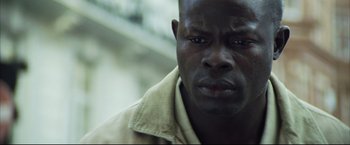 Movie still from “Blood Diamond” (2006), directed by Edward Zwick – A man's face in a tan shirt; Close Up shot, Low angle