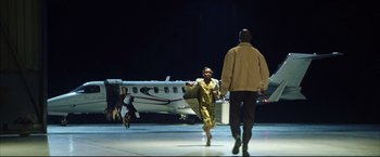 Movie still from “Blood Diamond” (2006), directed by Edward Zwick – A man and a woman walking away from an airplane at an airport; Extreme Wide shot, Low angle