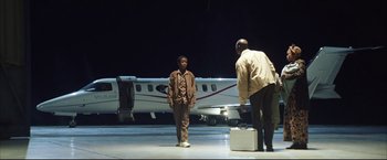 Movie still from “Blood Diamond” (2006), directed by Edward Zwick – Two men standing in front of a small airplane; Wide shot, Low angle