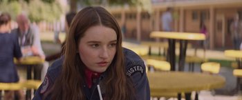 Movie still from “Booksmart” (2019), directed by Olivia Wilde – A woman with long hair sitting on a bench; Close Up shot, Over the shoulder angle