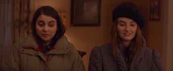 Movie still from “Booksmart” (2019), directed by Olivia Wilde – Two women sitting next to each other in front of a painting; Close Up shot, Over the shoulder angle