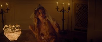 Movie still from “Booksmart” (2019), directed by Olivia Wilde – A woman wearing a tiara and veil in a dimly - lit room; Medium shot, Over the shoulder angle